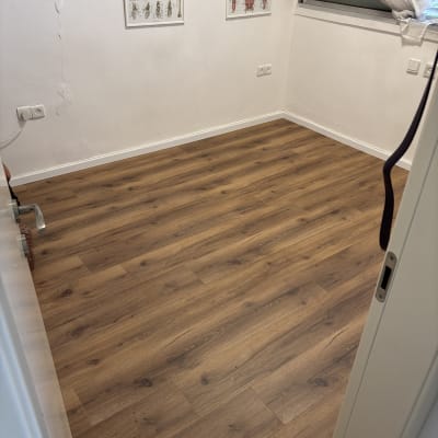 רצפת פרקט בחדר עם פוסטרים על הקיר