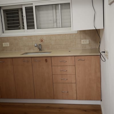 מטבח קטן עם ארונות עץ וכיור