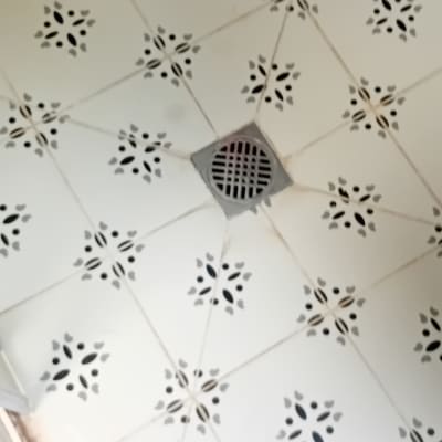 רצפת מקלחת עם אריחים ודליפה ליד הניקוז