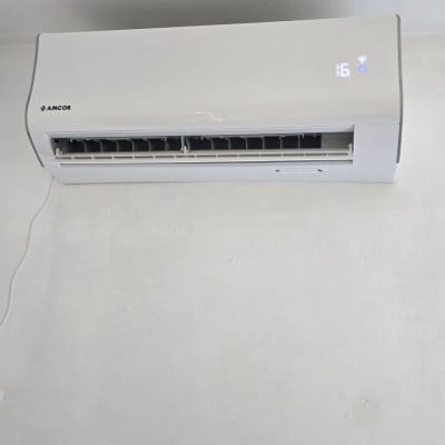 מזגן מותקן על קיר לבן עם תצוגה דיגיטלית