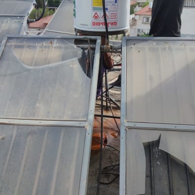 אדם מתקין דוד שמש על גג עם קולטים