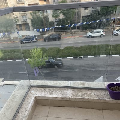 מעקה זכוכית שקוף במרפסת עם נוף לרחוב