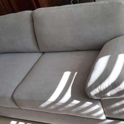 ספה אפורה עם כריות מרופדות וצללים