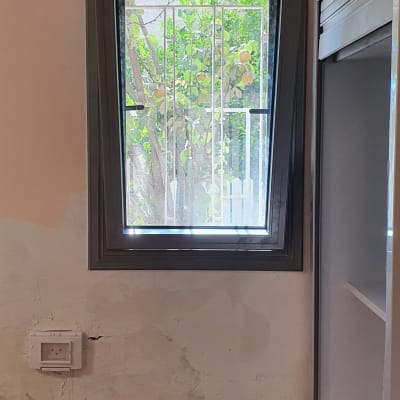 חלון אלומיניום עם מסגרת אפורה וקיר לבן