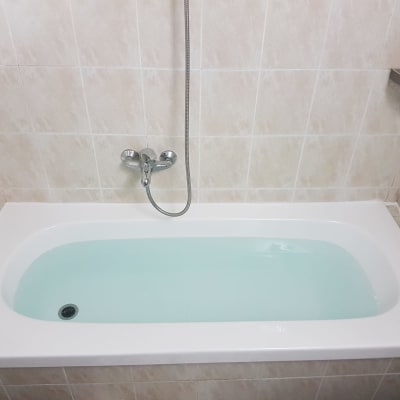 אמבטיה עם מים, ברז ומקלחת קיר