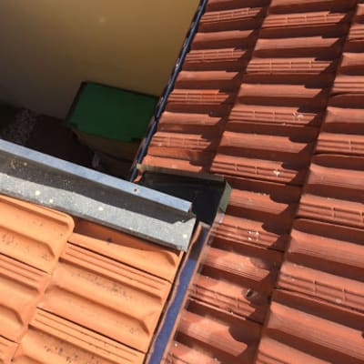 רעפים חומים על גג עם קורות מתכת כחולות