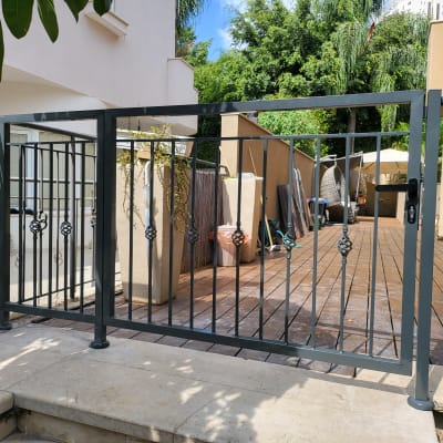 שער מתכת עם עיטורים על דק עץ