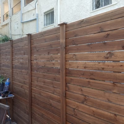 גדר עץ חומה גבוהה עם לוחות אופקיים