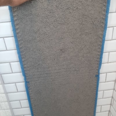 פילטר מזגן מלוכלך מוחזק ביד על רקע קיר לבנים