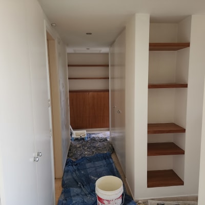 דלי צבע לבן ומברשת על יריעת כיסוי