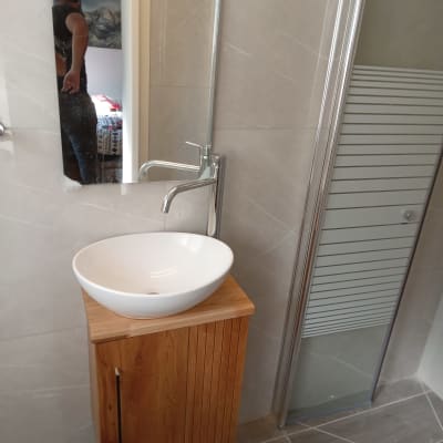 כיור עגול על ארון עץ בחדר אמבטיה