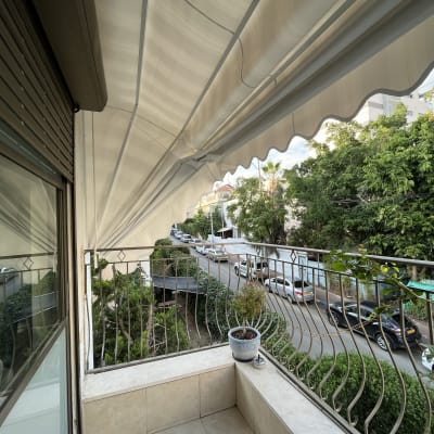מרפסת עם סוכך בד לבן פתוח מעליה