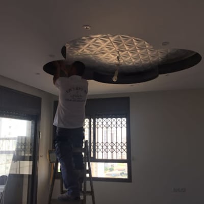 אדם על סולם מתקין תקרה מעוצבת