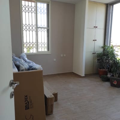 חדר עם קירות צבועים בצבע בהיר וקרטונים על הרצפה