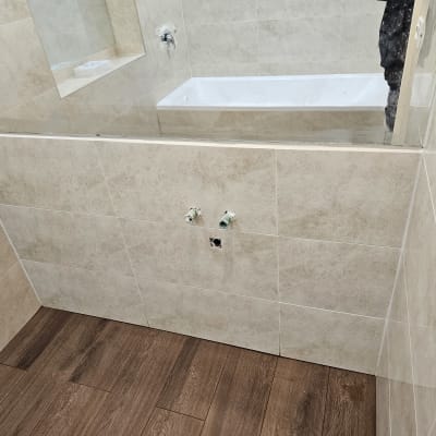 חדר אמבטיה בשיפוץ עם אריחים חדשים וברזים מותקנים