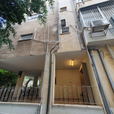 בניין עם צינורות חיצוניים ומזגן מותקן