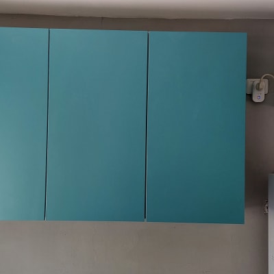 ארונות מטבח כחולים ומזגן על קיר אפור