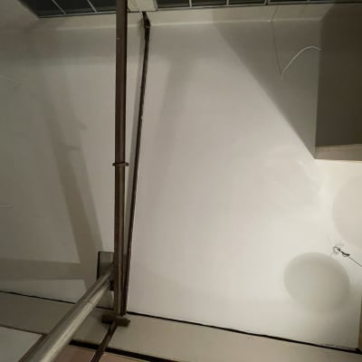 קיר גבס עם מנורה תלויה וחוטים חשופים