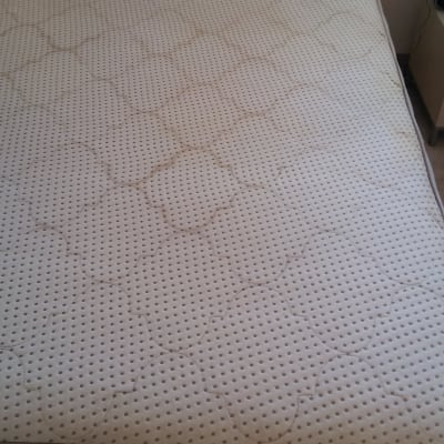 מזרן עם כתמים על כיסוי בד לבן