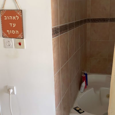 אמבטיה עם אריחים, בקבוקי שמפו וסבון