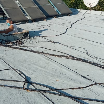 אדם עובד על גג עם יריעות איטום