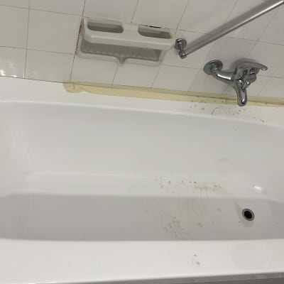 אמבטיה לבנה עם ברז וכיסוי קיר קרמיקה