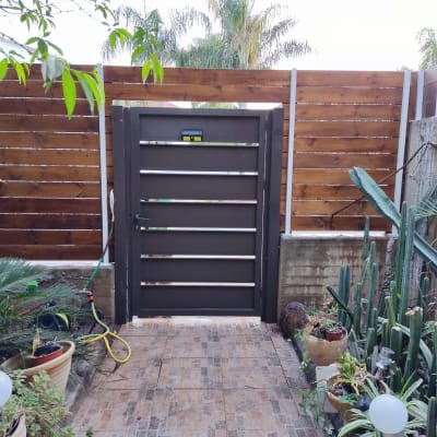 שער עץ בגינה עם צמחים מסביב