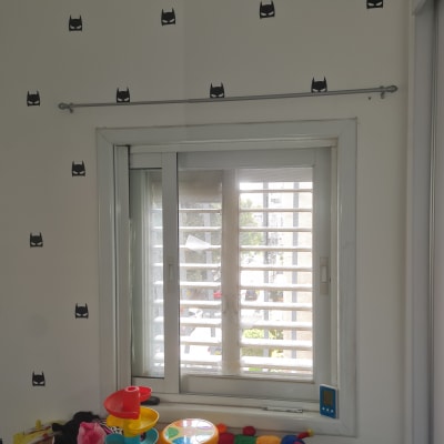 מוט תלוי מעל חלון עם מדבקות קיר