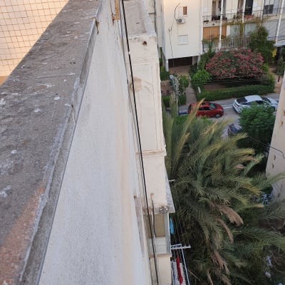 כבלים חשמליים תלויים לאורך קיר בניין