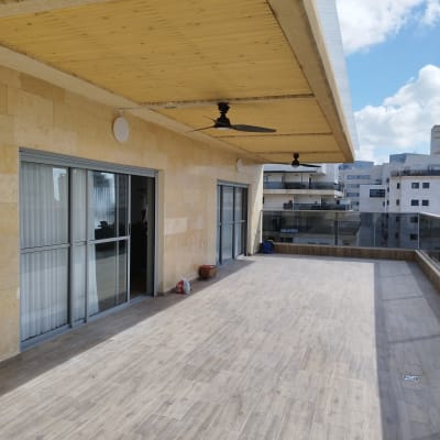 מרפסת עם רצפת דמוי עץ, עציצים ומאווררים