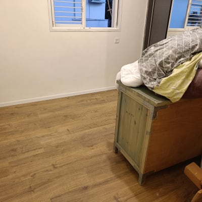 רצפת פרקט עץ בחדר ריק עם קיר לבן