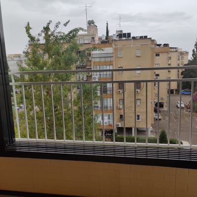 מעקה מתכת לבן עם מסגרת חלון שחורה