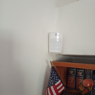 חיישן תנועה לבן מותקן על קיר לבן