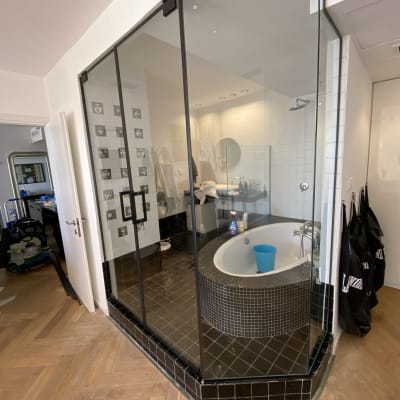 מקלחון זכוכית עם דלתות שחורות בחדר אמבטיה