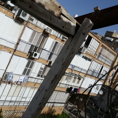 קורות עץ ישנות על גג תחת שמיים כחולים