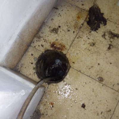 צינור מתכת מחובר לניקוז על רצפה מלוכלכת