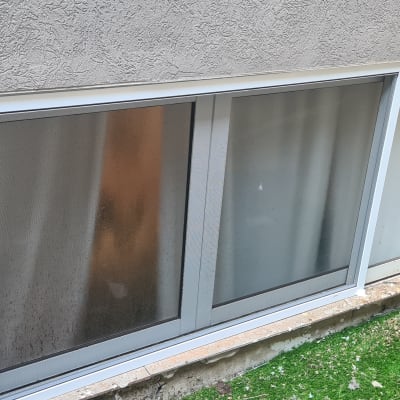 חלון אלומיניום עם מסגרת לבנה בקיר חיצוני