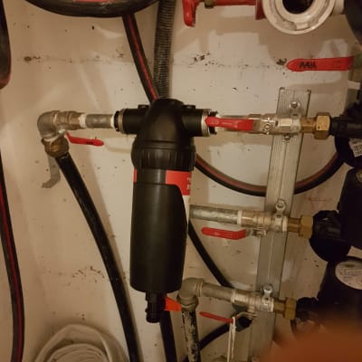 צנרת עם ברזים אדומים ומסנן מים שחור