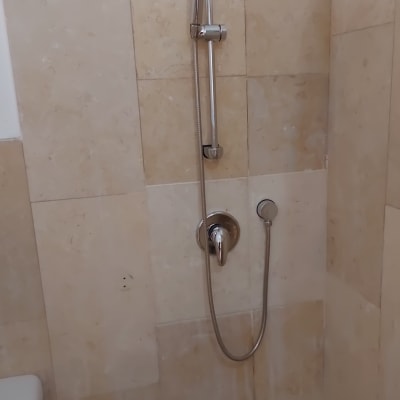 מקלחת עם אריחים ותיקון קיר חשוף