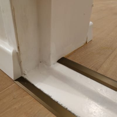 חיבור פרקט עם מסגרת מתכת ליד קיר לבן