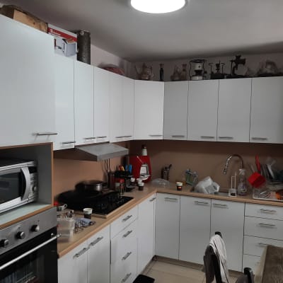 מטבח עם ארונות לבנים, תנור ומיקרוגל