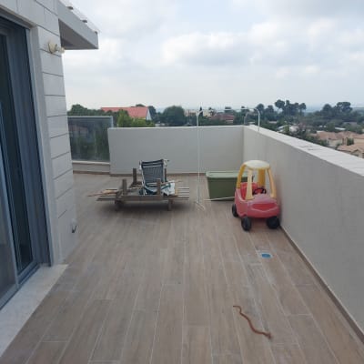 מרפסת עם רצפת עץ, צעצוע רכב אדום, כיסא הפוך