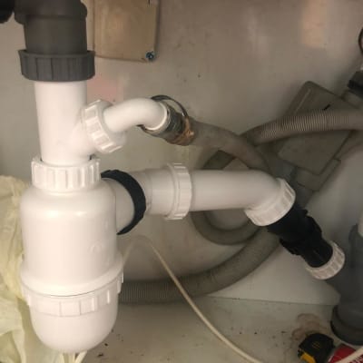 צנרת פלסטיק לבנה מתחת לכיור עם מחברים