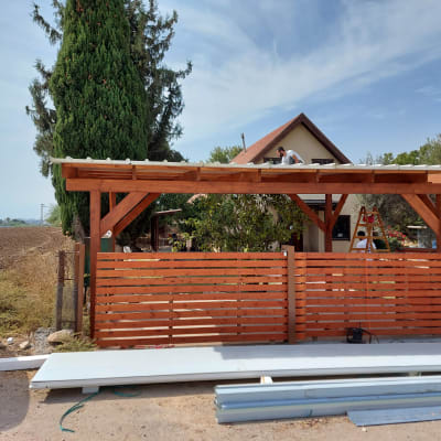 מבנה עץ עם גג, אדם עובד על הגג, סולם בצד