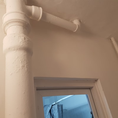 צינור צבוע בלבן על קיר ותקרה