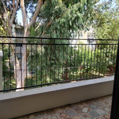 מעקה מתכת שחור במרפסת עם רצפת אריחים מעוטרת