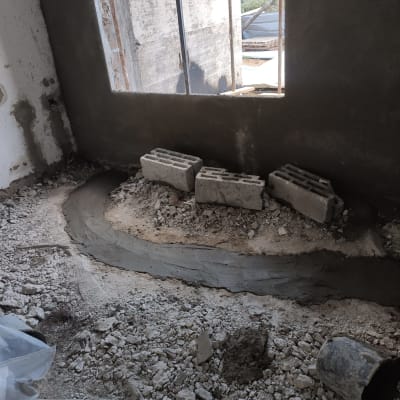 קיר בטון עם בלוקים, רצפה עם מלט וחצץ
