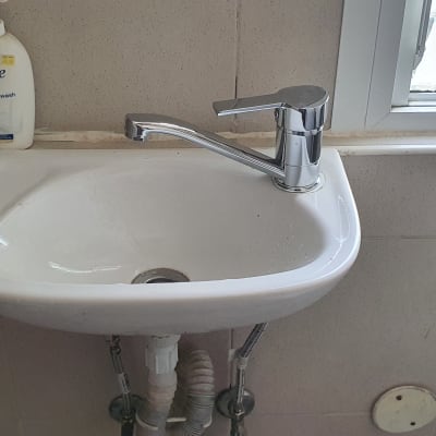 כיור עם ברז כרום וצינורות מתחת