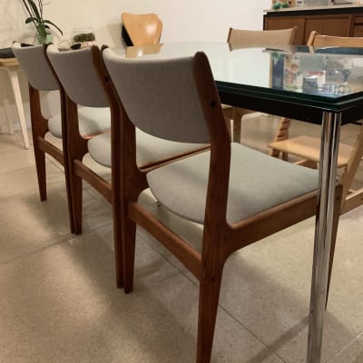 כיסאות עץ עם ריפוד אפור ליד שולחן זכוכית