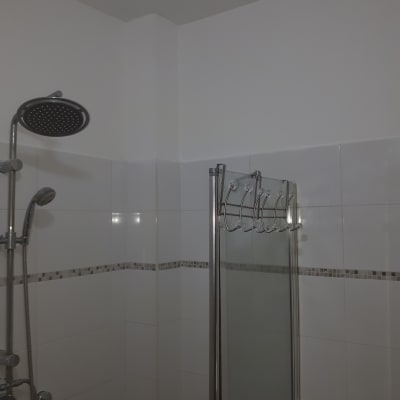 קיר צבוע בלבן עם אריחים במקלחת